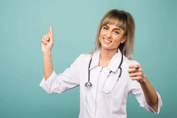 Bir stetoskop ile gülümseyen genç kadın doktor parmakları ile kamera içine ve içine puan — Stok fotoğraf