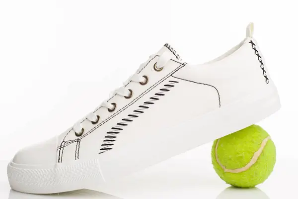 Sapatos de passeio brancos na moda com bola de tênis em um fundo branco . — Fotografia de Stock