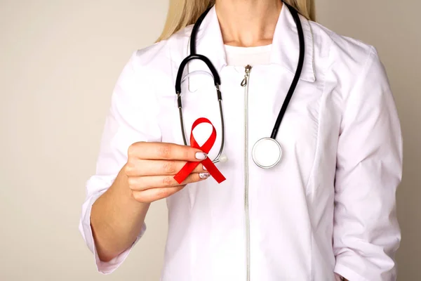 Female doctor with AID, HIV red ribbon. Cancer concept. Doctor H