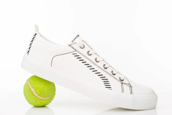 Модні білі кросівки з тенісним м'ячем на білому тлі . — стокове фото