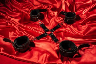 BDSM kıyafeti üst görünümü. Kırmızı keten üzerinde esaret geçti. Yetişkin Seks Oyunları. Kinky yaşam tarzı.