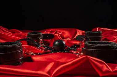 BDSM kıyafeti. Kırmızı keten üzerinde esaret ve gag topu. Yetişkin Seks Oyunları. Kinky yaşam tarzı.
