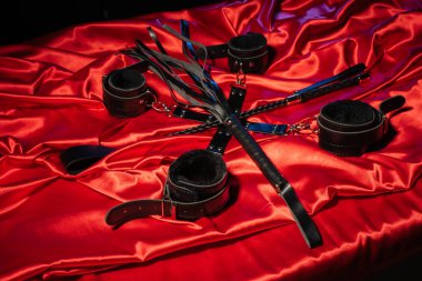 BDSM kıyafeti üst görünümü. Esaret ve kırbaç kırmızı keten üzerinde şaplak geçti. Yetişkin Seks Oyunları. Kinky yaşam tarzı.