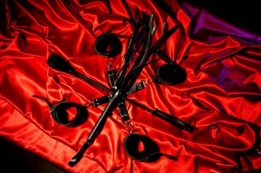 BDSM kıyafeti üst görünümü. Esaret ve kırbaç kırmızı keten üzerinde şaplak geçti. Yetişkin Seks Oyunları. Kinky yaşam tarzı.