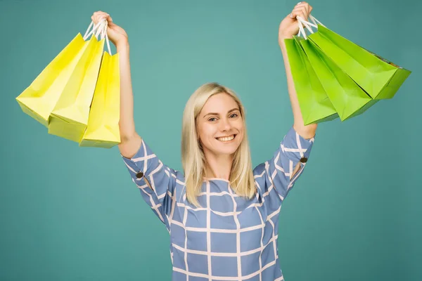 Lycklig tjej i en rutig blus rymmer shoppingväskor — Stockfoto