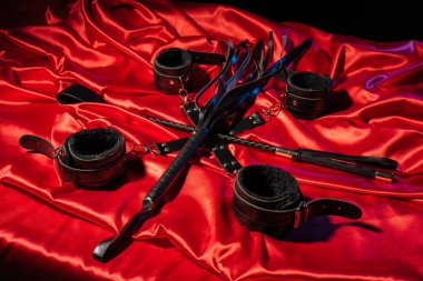 BDSM kıyafeti üst görünümü. Esaret ve kırbaç kırmızı keten üzerinde şaplak geçti. Yetişkin Seks Oyunları. Kinky yaşam tarzı.