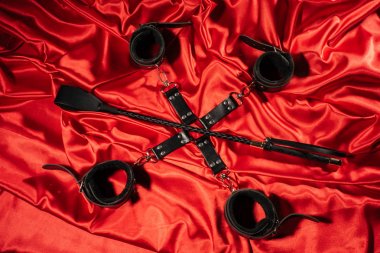 BDSM kıyafeti üst görünümü. Kırmızı keten üzerinde esaret ve şaplak. Yetişkin Seks Oyunları. Kinky yaşam tarzı.