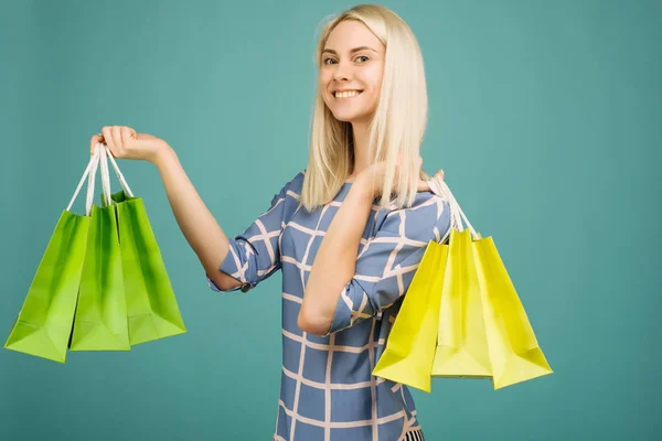 Lycklig tjej i en rutig blus rymmer shoppingväskor — Stockfoto