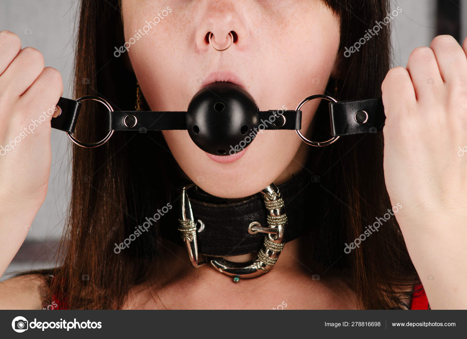 БДСМ костюм для взрослых секс-игр. Молодая женщина с воротником держит кляп  во рту . стоковое фото ©unomay 278816698