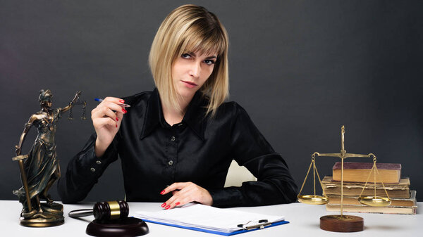 A young fair woman judge works in her office.