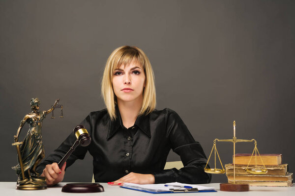 A young fair woman judge works in her office.