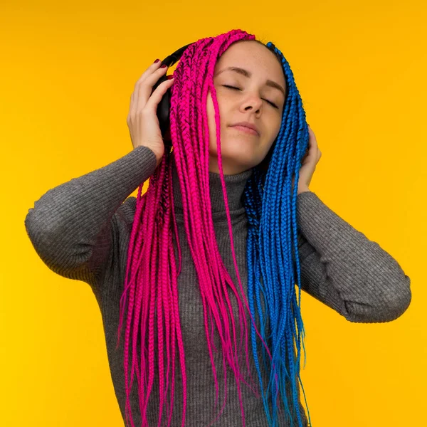 Mujer alegre feliz con trenzas senegalesas y pecas con auriculares inalámbricos escuchando música desde el teléfono inteligente — Foto de Stock