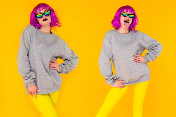 Wo lesbiana chica en rosa peluca y arco iris gafas de sol posando sobre amarillo fondo . — Foto de Stock