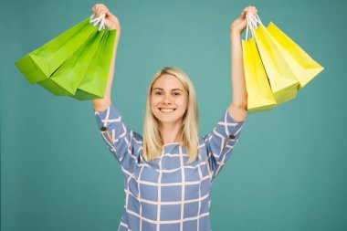 Damalı bluzlu mutlu kız alışveriş çantaları tutar