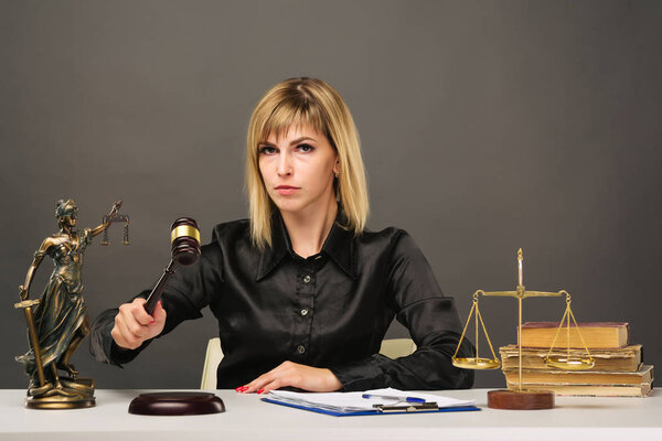 A young fair woman judge works in her office.