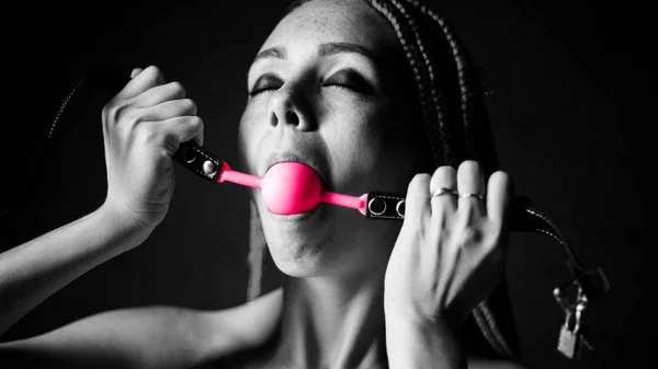 BDSM outfit voor Adult Sex Games. Een jonge vrouw likt roze gag bal. Zwart-wit — Stockfoto