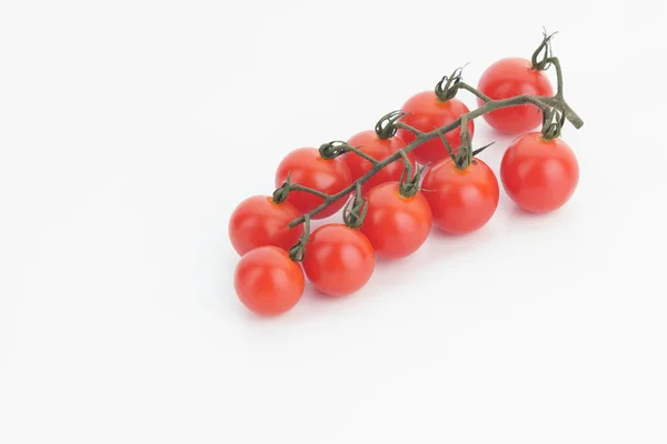 Tomates cherry maduros sobre una ramita sobre un fondo blanco — Foto de Stock