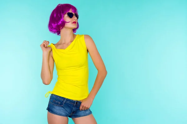 Retrato de mujer joven transgénero en peluca rosa y gafas de sol, camiseta amarilla — Foto de Stock