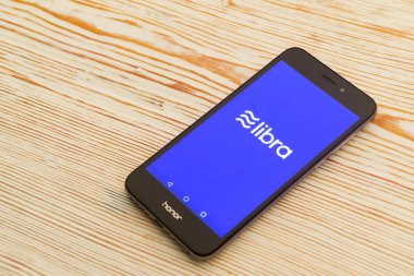 Tula, Rusya - 4 Temmuz 2019 : Beyaz ahşap masada akıllı telefon bulunan Terazi sikke blockchain konsepti