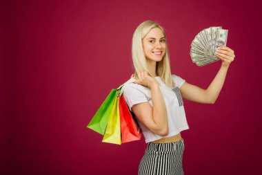 Mutlu kız yüz dolar faturaları ve alışveriş çantaları tutar