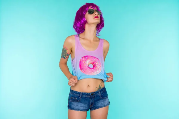 Retrato de jovem transgênero em peruca rosa e óculos de sol em fundo azul — Fotografia de Stock