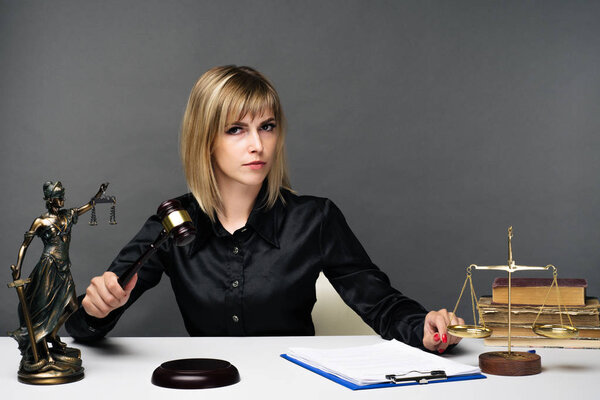 A young fair woman judge works in her office.
