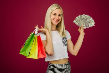 Mutlu kız yüz dolar faturaları ve alışveriş çantaları tutar