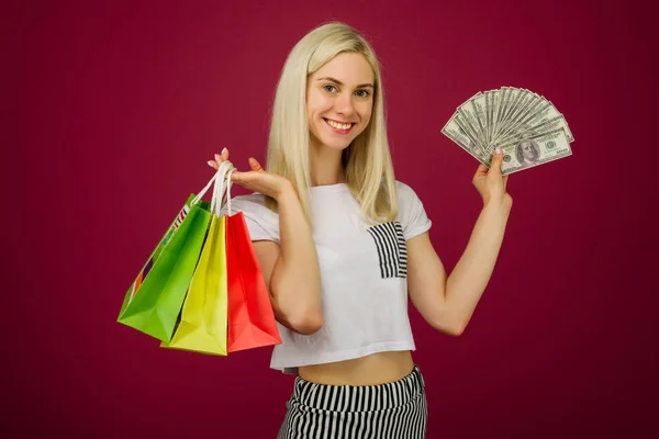 Šťastné děvče drží 100 dolarů a nákupní tašky — Stock fotografie