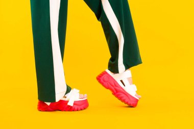 Kırmızı taban ve yeşil pantolon zeka ile spor sandalet kadın bacakları