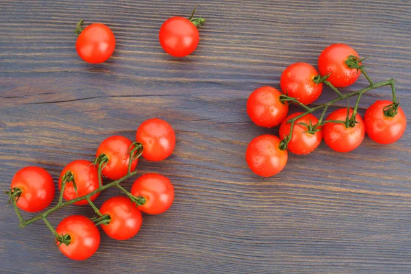 Dojrzałe pomidory wiśniowe na gałązką na ciemnym Woden tle — Zdjęcie stockowe