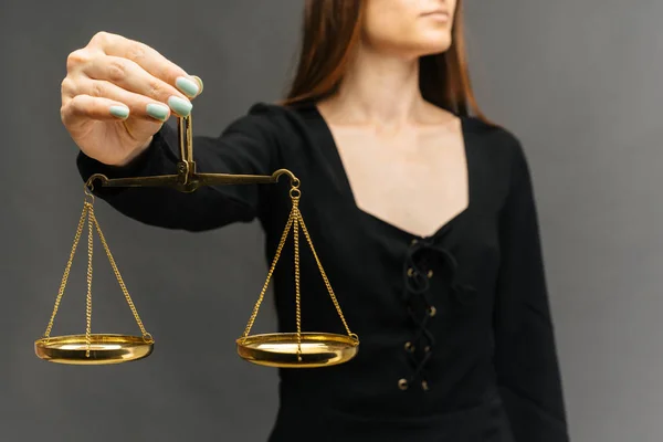 Mujer seria sosteniendo la escala de la justicia sobre fondo oscuro —  Fotos de Stock