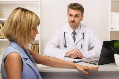 Ofiste bir erkek cerrah veya terapist ile bir danışmadan genç kadın.