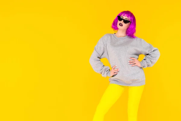 Retrato de chica de moda sobre fondo amarillo. Mujer joven de estilo loco en peluca rosa — Foto de Stock