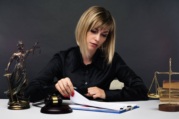 A young fair woman judge works in her office.