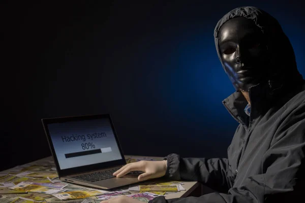 Programador de hackers anônimo usa um laptop para hackear o sistema no escuro. Criação e infecção de vírus malicioso. O conceito de cibercrime e base de dados de pirataria — Fotografia de Stock