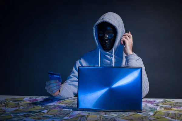 Hacker anônimo no programador máscara usa um laptop para hackear o sistema no escuro . — Fotografia de Stock