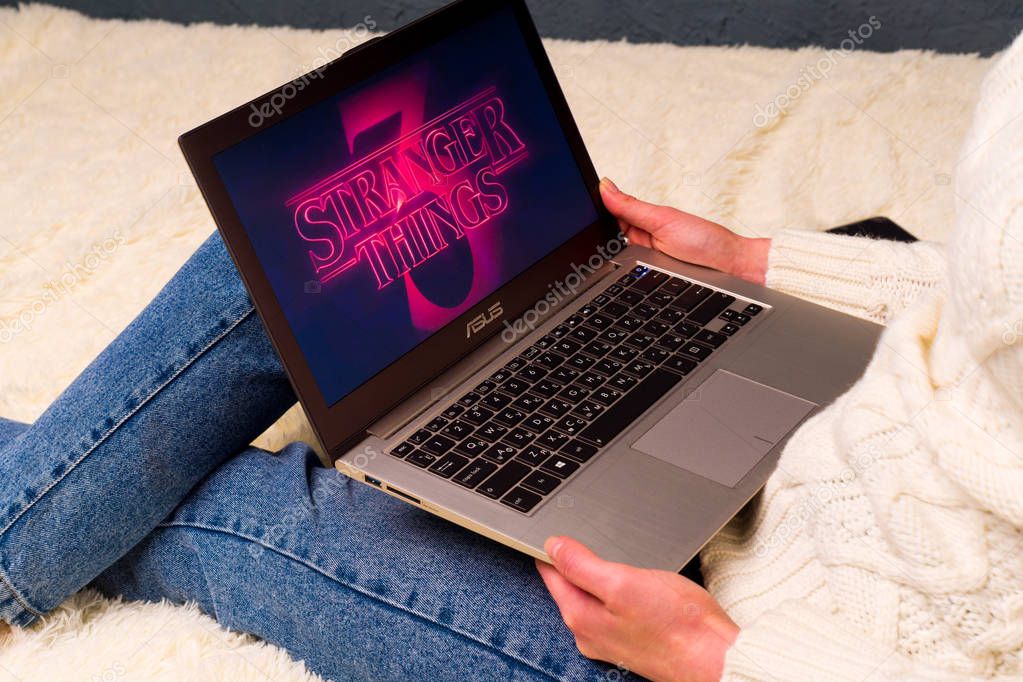 TULA, RUSSIA -AUGUST 19 2019: Stranger Things 3 from Netflix TV series Poster.Woman sitting on bed preparing to watch a series Stranger Things Season 3