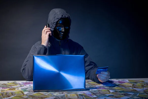 Anonyme Hacker in Maske Programmierer verwendet einen Laptop, um das System im Dunkeln zu hacken. — Stockfoto