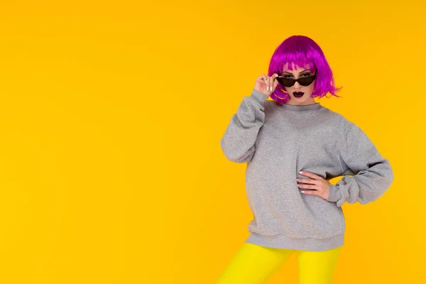 Retrato de menina de moda no fundo amarelo. Louco estilo jovem mulher em peruca rosa — Fotografia de Stock
