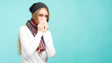 Sağlık ve tıp kavramı - Üzgün Teen Girl doku içine burun üfleme, mavi bir arka plan üzerinde. Güzel kız som ile soğuk.