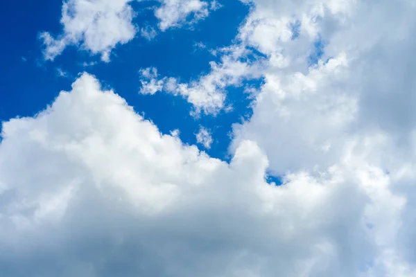 青い空の背景に白いふわふわの雲 — ストック写真