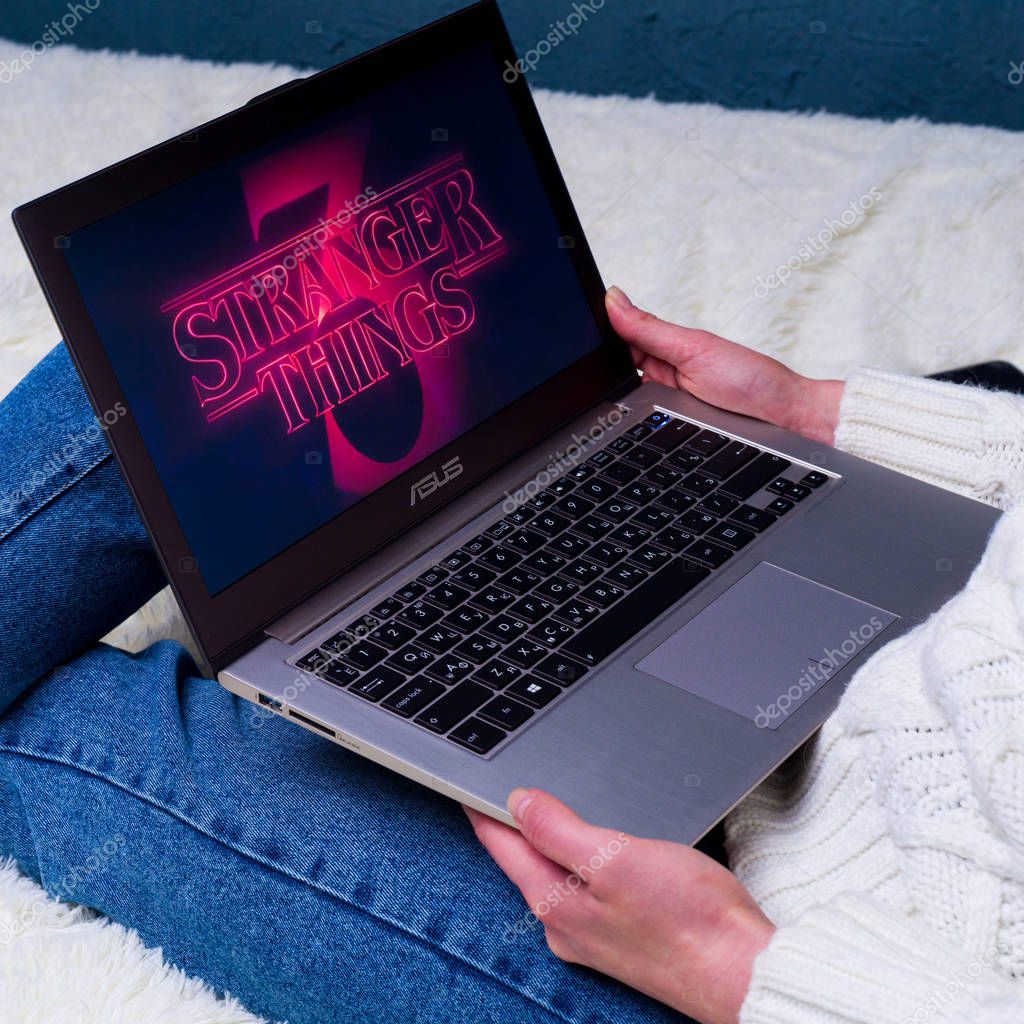 TULA, RUSSIA -AUGUST 19 2019: Stranger Things 3 from Netflix TV series Poster.Woman sitting on bed preparing to watch a series Stranger Things Season 3