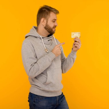 Gri kapüşonlu çekici adam kredi ca bir parmak işaret