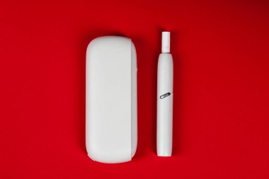 Tula, Rusya, 17 Eylül 2019: Top view Iqos 3. Şirket Philip Morris, kırmızı bir arka plan üzerinde izole tütün sistemi ısıtma