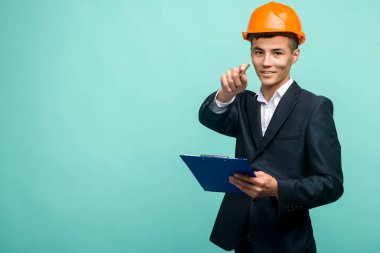 Sert bir şapka giyen ve kamera bir pano noktası taşıyan genç bir profesyonel