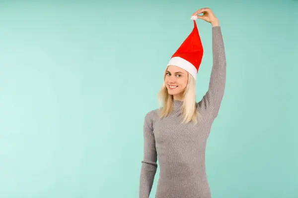 A beautiful sexy girl in gray dress, hold in handsa New Year 's hat. Празднование Рождества или Нового года на синем фоне — стоковое фото