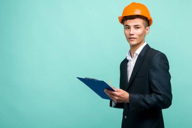 Sert bir şapka takan ve pano taşıyan genç bir profesyonel