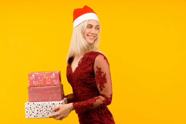 Красивая сексуальная девушка в новогодней шляпе и сером платье, держите в руках подарки. Празднование Рождества или Нового года — стоковое фото