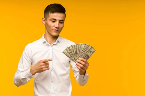 Joyful Asian man i en vit skjorta pekar ett finger på pengar Dolla — Stockfoto