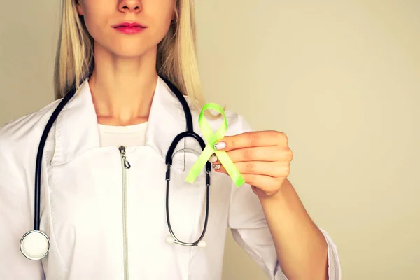 Female doctor in white uniform with light green ribbon awareness in hand for Celiac Disease, Chronic pelvic Pain, Human Papilloma Virus, Sexually Transmitted Diseases STD, Medical Healthcare concept - Image